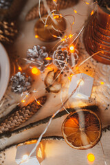 Christmas New Year top view of handmade crafts with pine cones, dry round slices of oranges, garland, branches. New year holiday, celebration concept. Flatlay