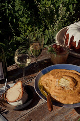 A bowl of grits on a table with wine and cocktails