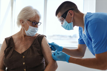 doctor giving an injection to an elderly woman covid passport treatment immunity protection