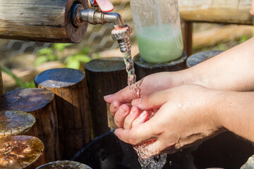 Woman washing her hands outdoors in Rio de Janeiro.