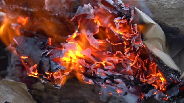 Burning paper. Bonfire on the stones. Hot fire. Close-up. Flame and smoke. Fire for a kebab. Rest of the tourist. Waste incineration.