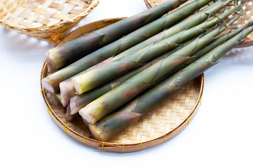 Fresh bamboo shoots in basket on white background.