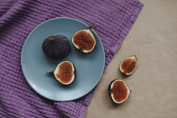 ripe fresh figs and purple textiles on rustic background, flatlay, overhead view