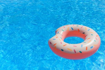 Inflatable swim ring in shape of donut floating in pool