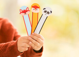 Little child with cute bookmarks at home