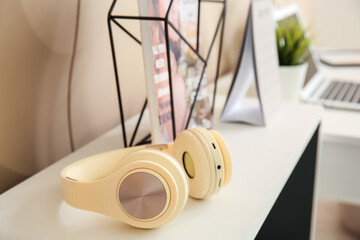 Modern headphones on shelf in room, closeup