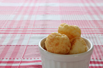 Cheese Bread in a white ramekin in a red chess background