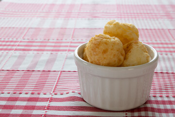 Cheese Bread in a white ramekin in a red chess background
