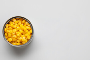 Opened tin can of corn kernels on white background