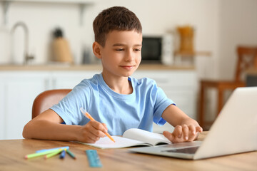 Little boy studying online at home