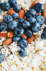 Crumbly curd with blueberries, almonds and chia seeds, close up.