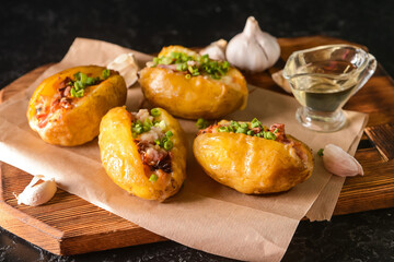 Board with baked potato on table