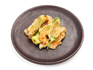 Plate with fried zucchini flowers on white background