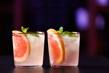 Glasses of tasty grapefruit margarita on table in bar