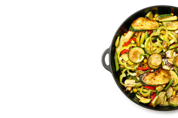 Frying pan with different vegetables on white background