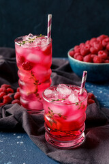 Glasses of tasty raspberry lemonade and berries on table
