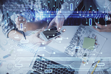 Double exposure of data theme hologram drawing and man and woman working together holding and using a mobile device.