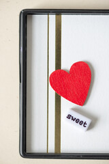 the word "sweet" with a red heart on fancy paper