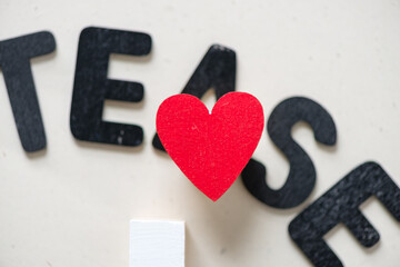out of focus word "tease" with a red heart