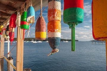 Colorful working boat lobster floatS hanging on the deck of a lobster processing plant with lobster...