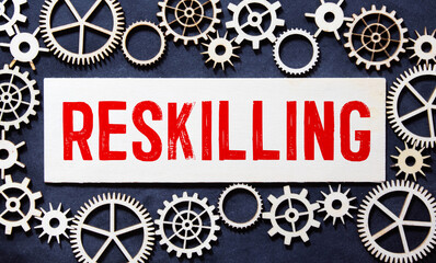word Reskilling on wooden card. Work of gears. Turn to next normal in financial concept.