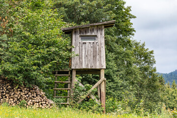 A wooden raised hide of a hunter at a clearing