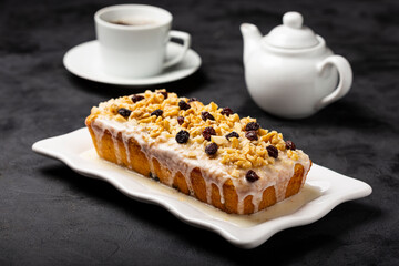 English cake topped with fondant, raisins and walnuts.