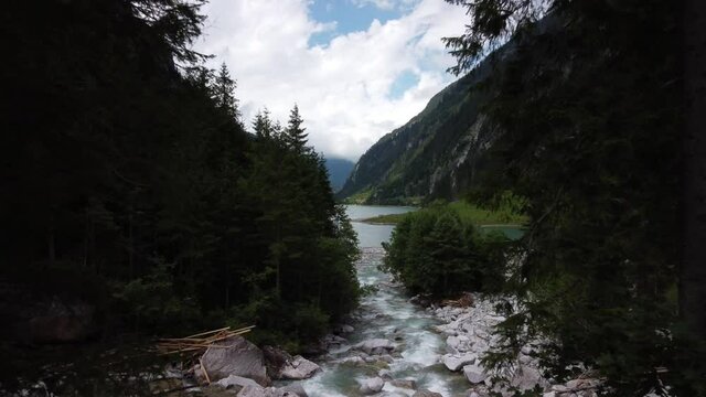 Bach am Stillup Speichersee im Zillertal in &Ouml;sterreich n&auml;he Meyrhofen, Drohnen Aufnahme &uuml;ber dem Bach hin zum See, Landschaft zwischen Berg und Tal in den Alpen