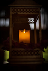 Flame of a candle enclosed into metal lantern
