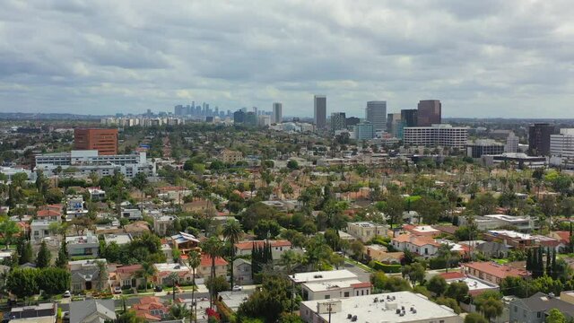 Flying over Beverly Hills residential area with Los Angeles skyine in view