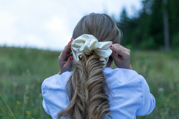 Back view of a blonde female with a beautiful trendy scrunchy on her hair