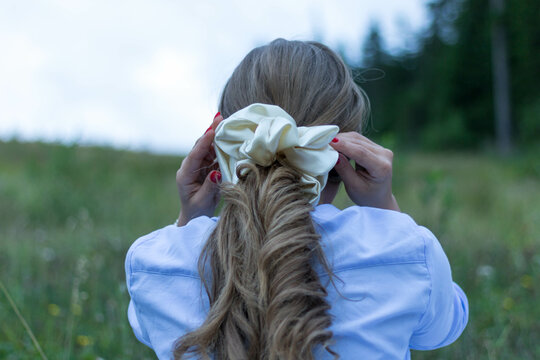 Back view of a blonde female with a beautiful trendy scrunchy on her hair