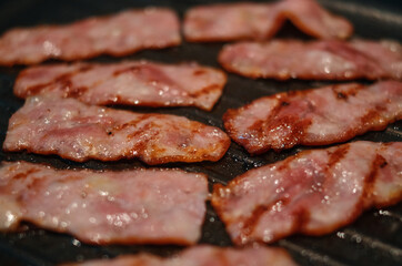 Close up of grilled bacon on the frying pan