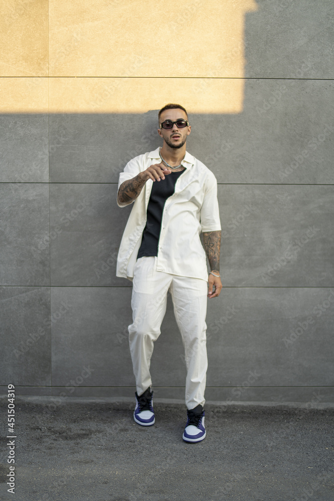 Poster vertical shot of a white caucasian guy posing for a photoshoot outdoors