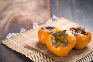 Ripe persimmon fruit on wooden background