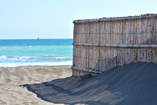 茅ヶ崎海岸の砂浜に映る防砂フェンスの影