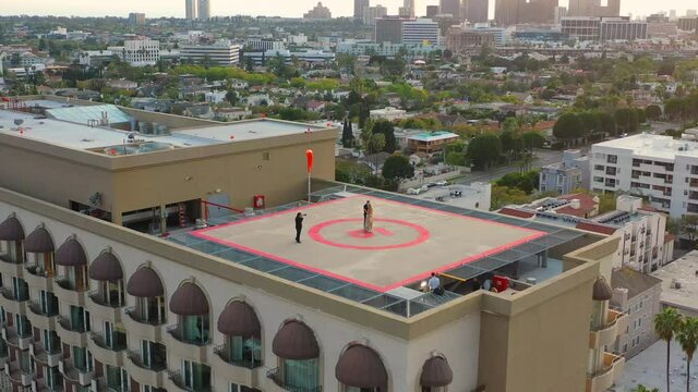 Bride and groom being photographed on helipad in Beverly Hills