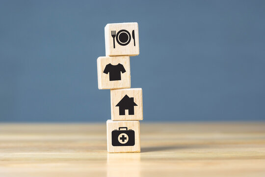 Wooden Cube With Food Clothing, Housing, Medicine, Four Basic Human Needs Concept.