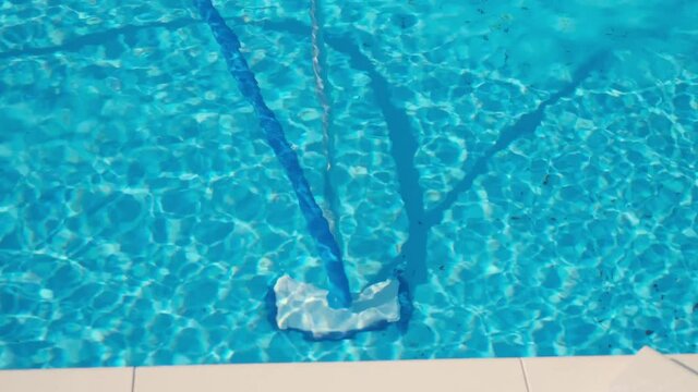 Vacuum cleaner for shooting over water with a long handle and a brush for cleaning the pool. The concept of cleaning the pool at home. Plastic pipes in the pool clean various water pollution