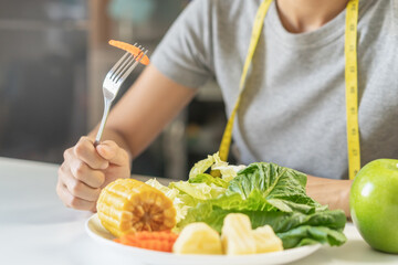 Diet, Dieting young asian woman or girl use fork at carrot on vegetables salad plate, eat green food is low fat good health not choose eat junk food. Nutritionist female, Weight loss person.