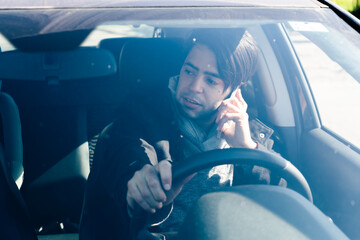Man talking on cell phone while driving a car. Concept road safety,