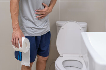 Diarrhea , Abdominal pain, Constipation concept. Men have contraction and stomach pain. Man holding toilet paper in toilet.