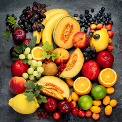 Assorted fresh fruits on dark background.
