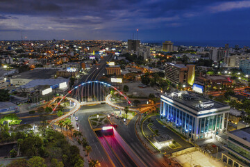 Landscape of a modern city surrounded by lights in the evening in the Dominican Republic - obrazy, fototapety, plakaty