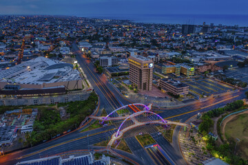 Landscape of a modern city surrounded by lights in the evening in the Dominican Republic - obrazy, fototapety, plakaty