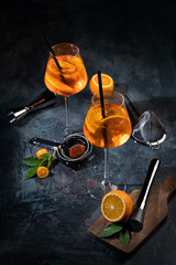 Aperol spritz cocktail served on dark background.