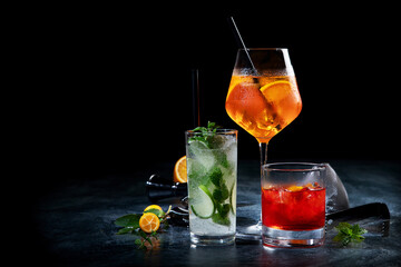 Cocktails assortment served on dark background.