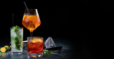 Cocktails assortment served on dark background.