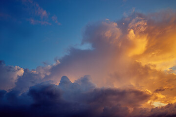 Clouds illuminated by the sun in the evening sky at sunset on a summer day