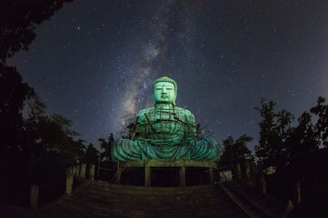 Daibutsu or 'Giant Buddha' is a Japanese term often used informally for a large statue of Buddha, Time lapse Giant Buddha with milky way moving in sky at night, Mae Tha District, Lampang Province.